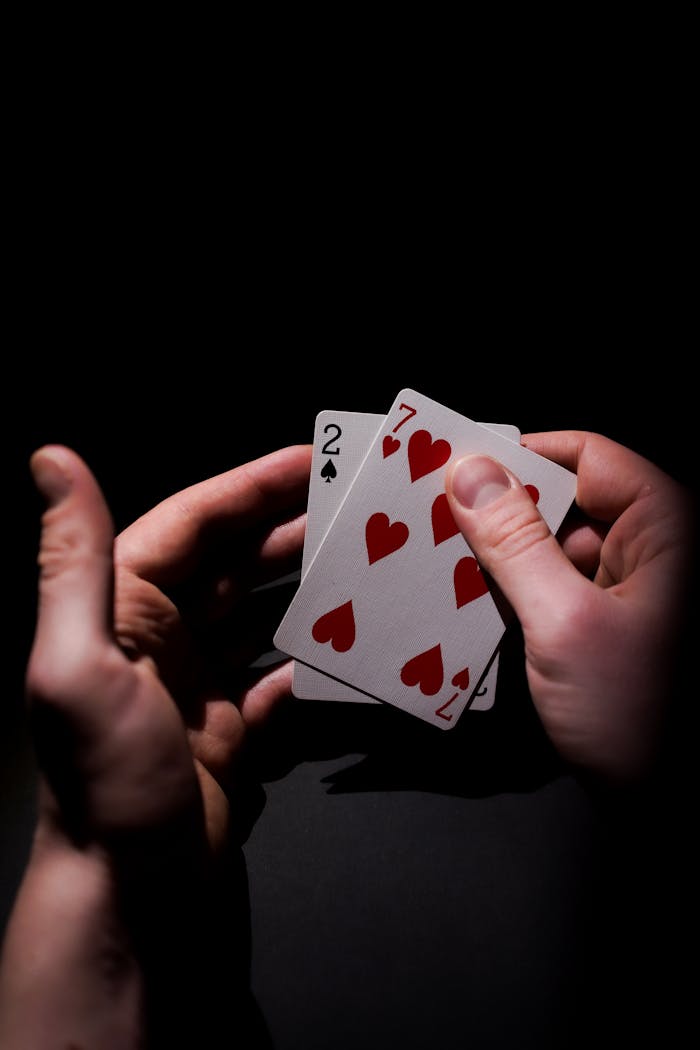 Intense close-up of poker cards in a players hand, highlighting the suspense of gambling.